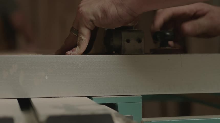 A man adjusts some knobs on a table saw