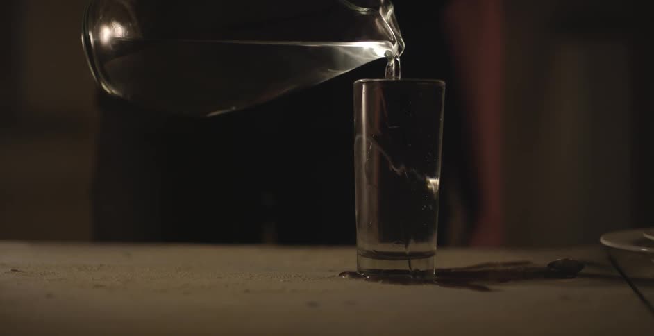 A glass is being overfilled with water