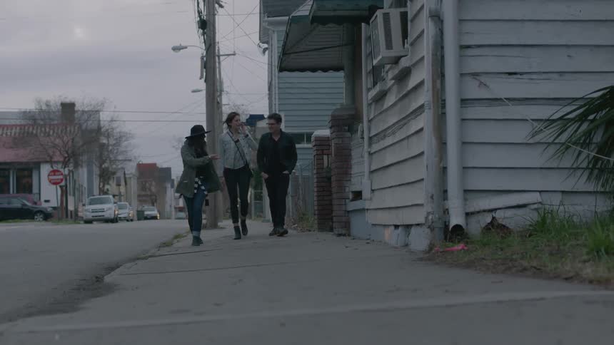 Three young adults walking down a city street