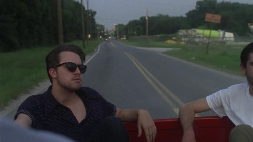 People riding in the back of a red pickup truck