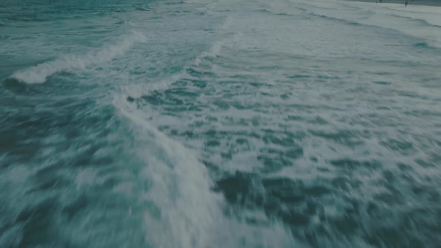 Ocean waves flowing towards shore at dawn