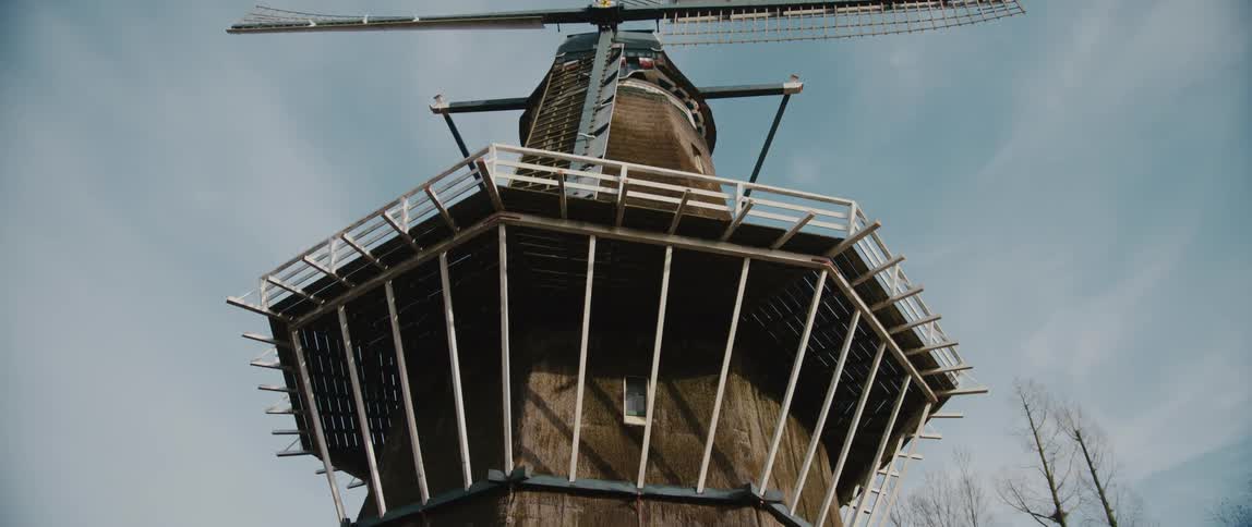 Sloten windmill in Amsterdam stands tall beneath a cloudy sky