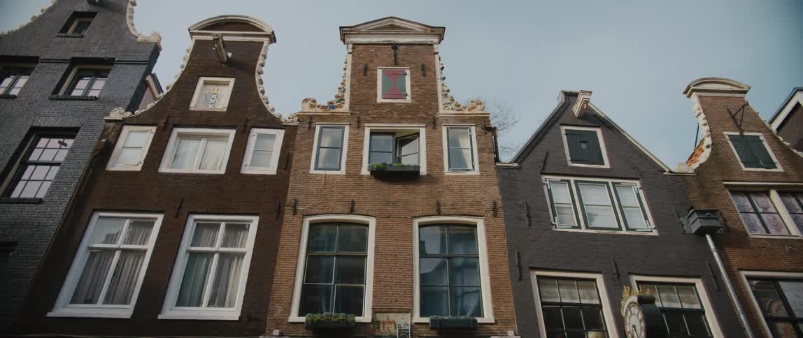 Canal homes in Amsterdam, some decorated with window boxes.