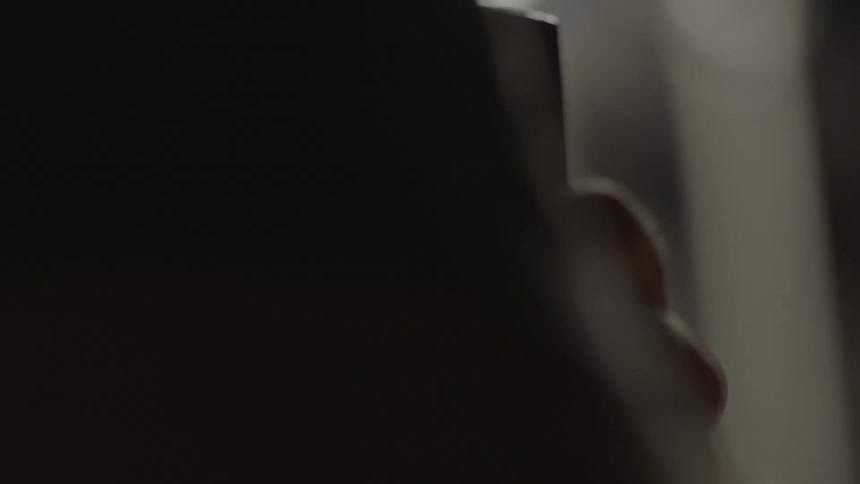 A person is holding onto something in a dark area