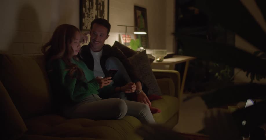 A man and woman sit on a couch and talk