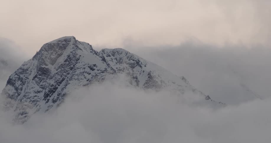 A winter mountain range is covered with heavy clouds