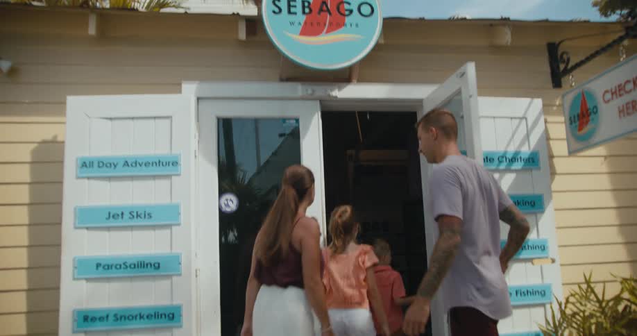 A family holds hands as they walk into a business selling boats