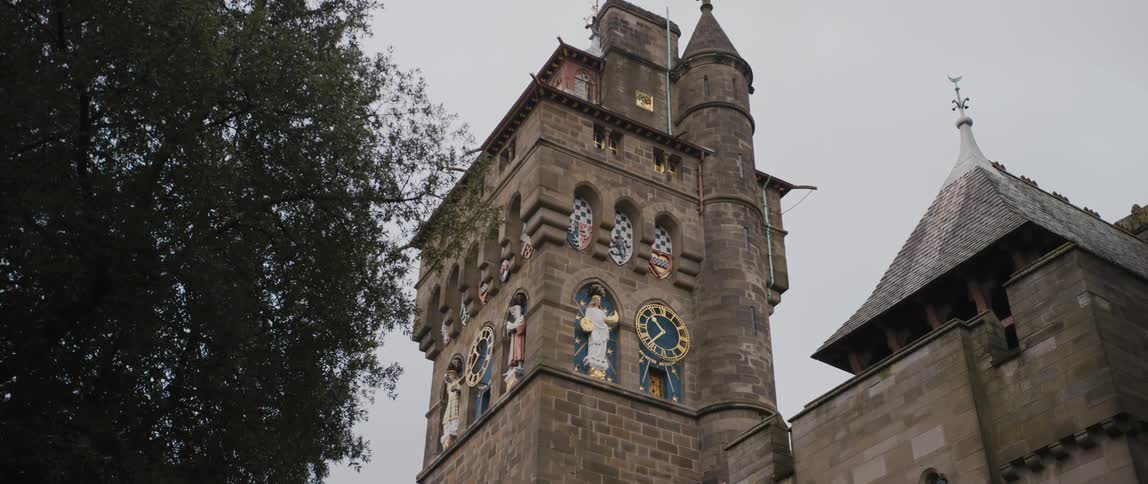 A tall clocktower is in the cloudy sky