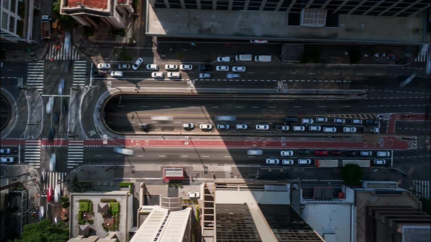 Hyperlapse of cars travelling on the multilane streets of Paulista Av. between the buildings in the city on a sunny day