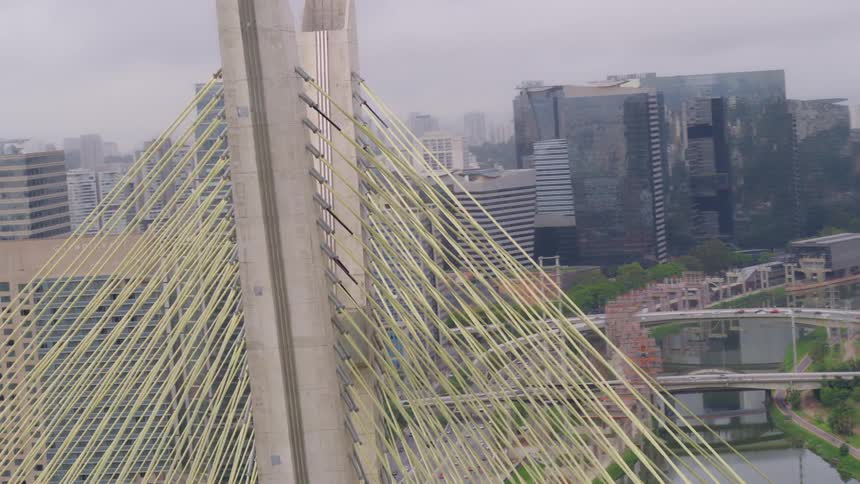 The octavio frias de oliveira bridge in sao paulo, brazil with the city skyline and highway system behind