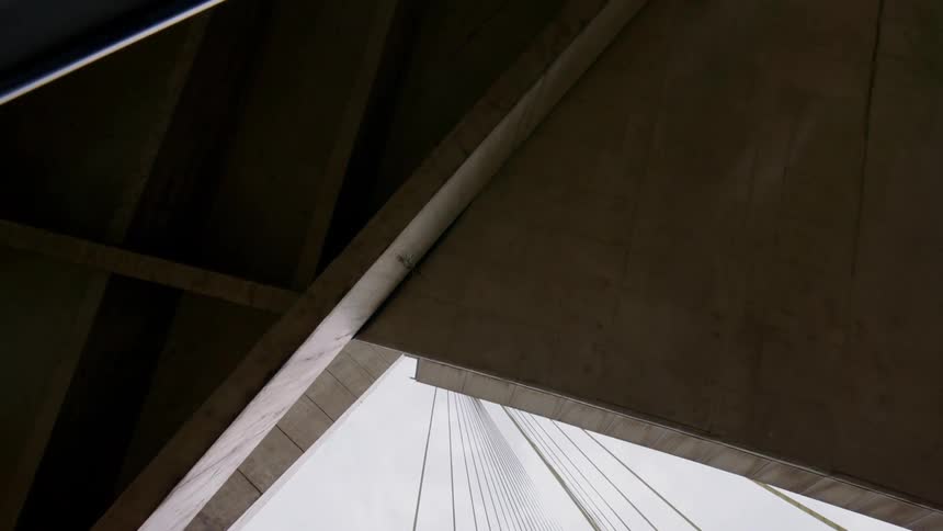 Tall cement structure of a cable-stayed bridge under a cloudy blue sky