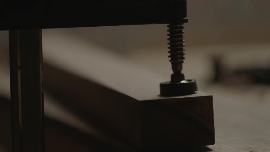 A man tightening a wood clamp