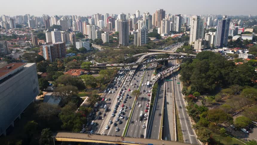 Large highway in the middle of a big city with busy traffic at junction in sunny day
