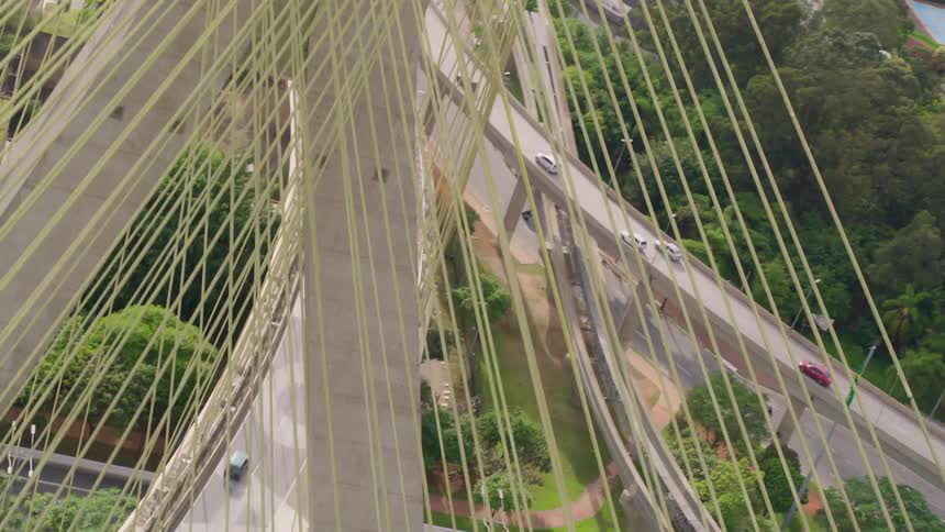 Vehicles travel on cable-stayed bridge and overpasses near the skyscrapers in the city