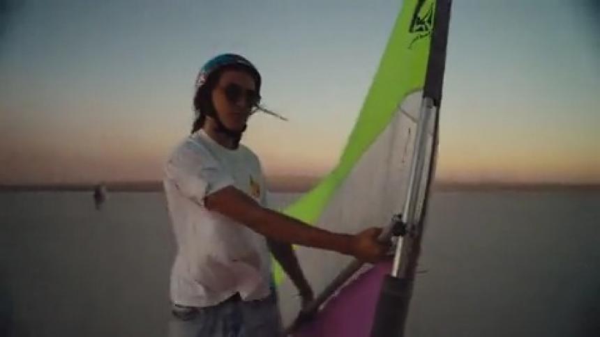 A young man rides a wind powered skateboard across a salt flat