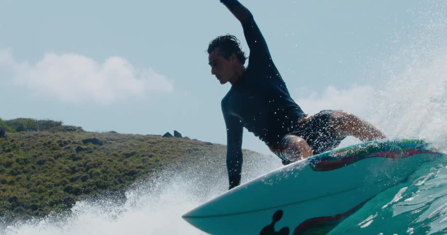 A surfer turns on the crest of a wave and rides it as it curls and breaks