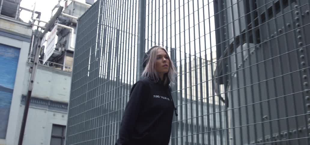 Woman wearing a black hoodie walking on the street turning around and walking the other way