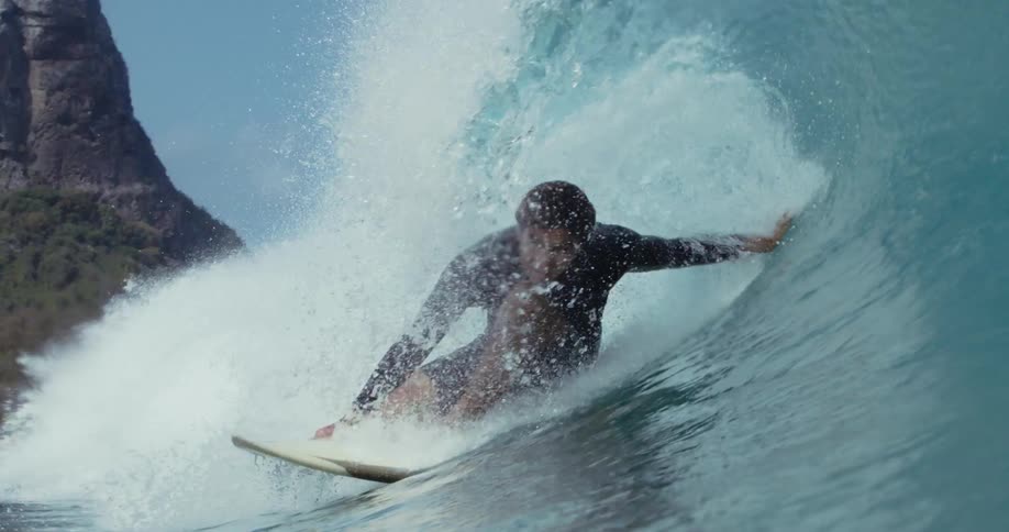 A male surfer riding a wave on a summer day