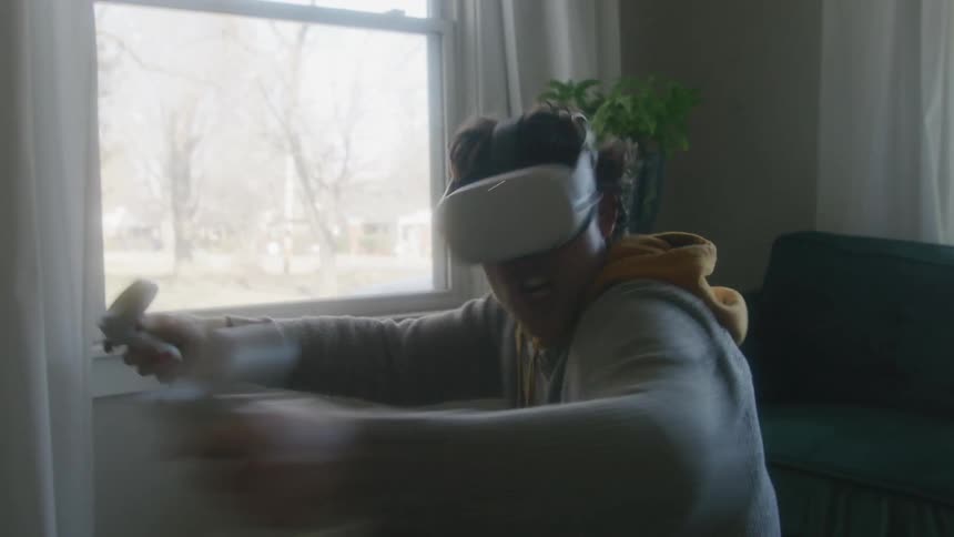A man crouching and punching the air while wearing a virtual reality headset