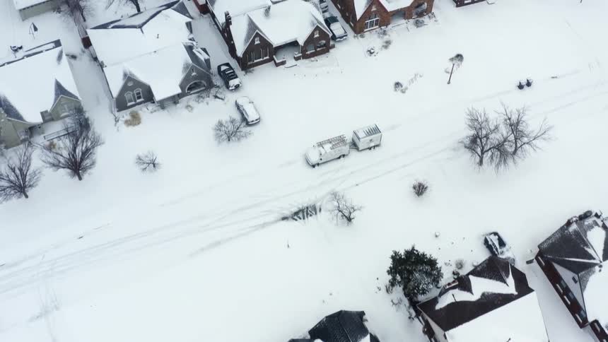 Aerial view of neighborhood homes yards and streets covered in snow