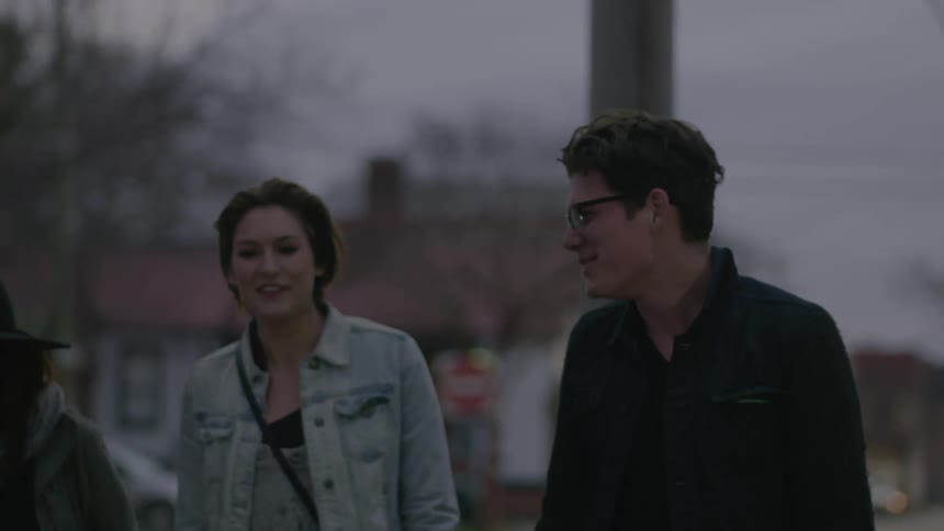 Three young adults walking down a city street
