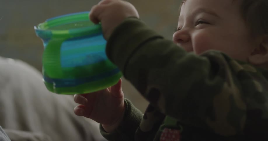 A boy laughs as he waves a container