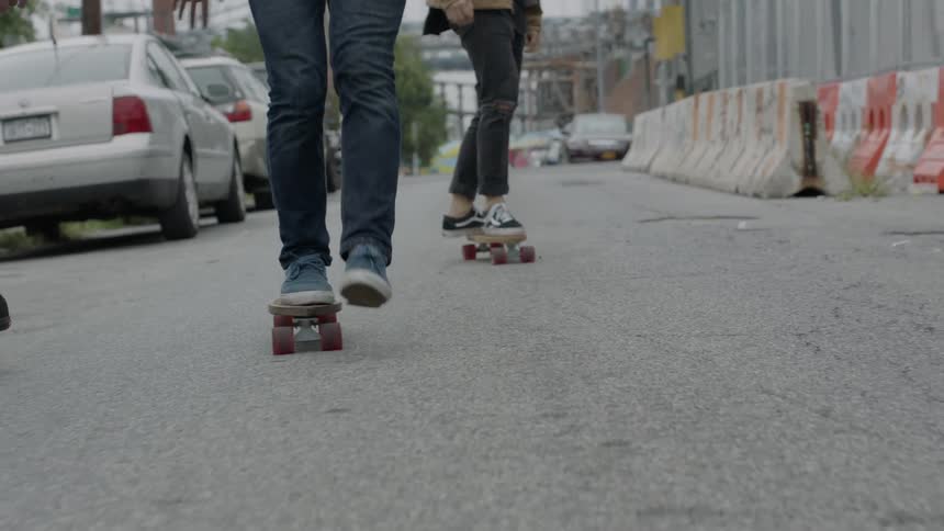 People skateboarding down a street
