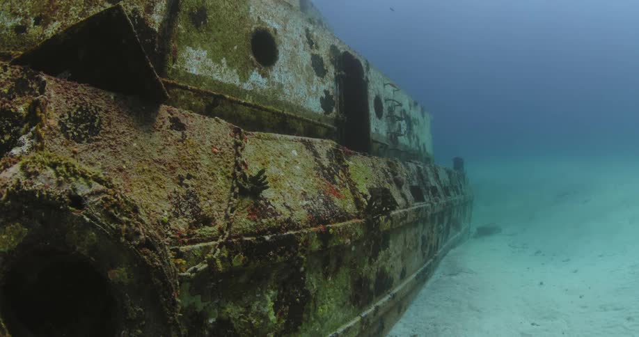 Encrusted sunken shipwreck sits on seafloor