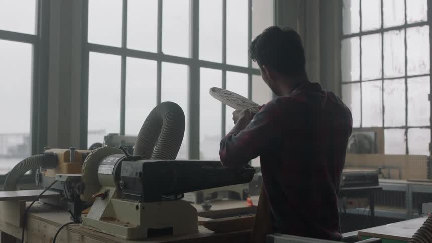 A man is examining a board in a shop