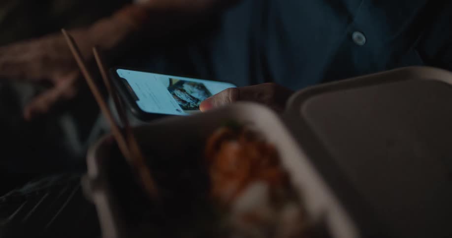 A person uses their thumb to continuously scroll through images on the screen of their smart phone