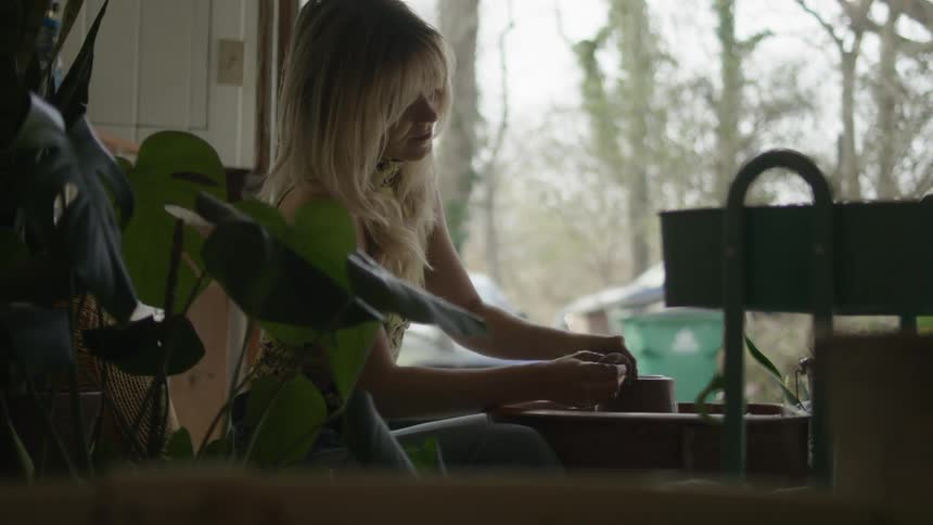 A woman is sculpting with clay