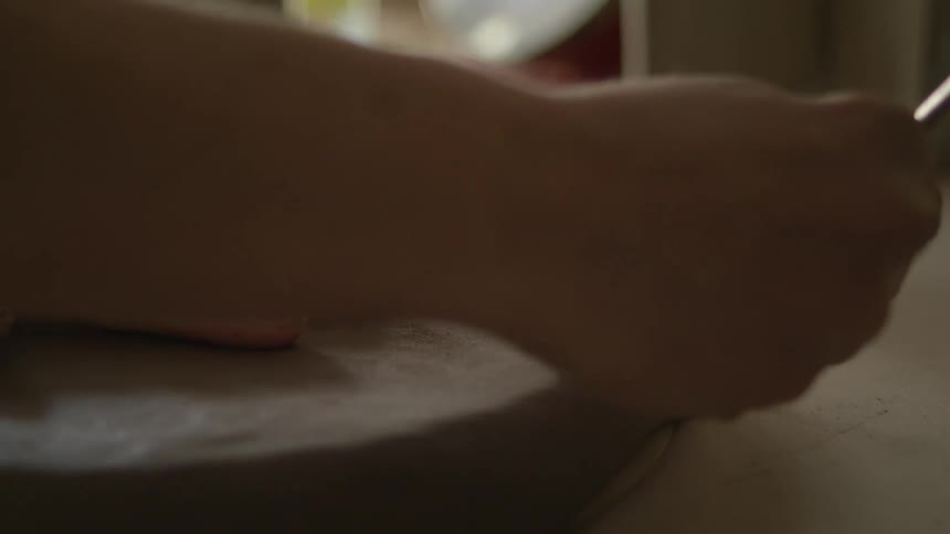 Person etches clay with handheld tool