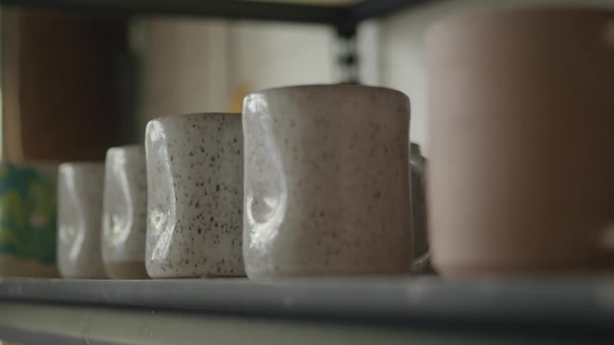 Ceramic cups are sitting on a shelf