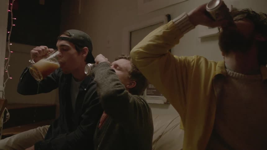 Three people drinking while sitting on a couch