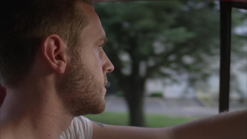 A man is driving a car looking around