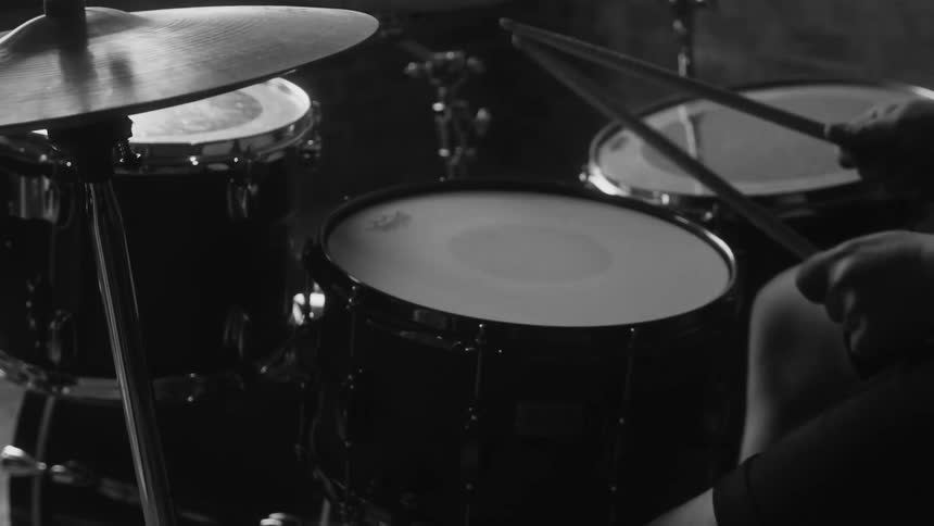 A man sits and plays the drums