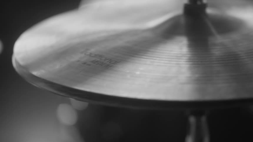 Light shimmers on cymbals on a drum set drummer