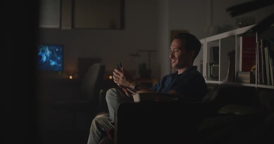 A man eats during a video call on his smartphone