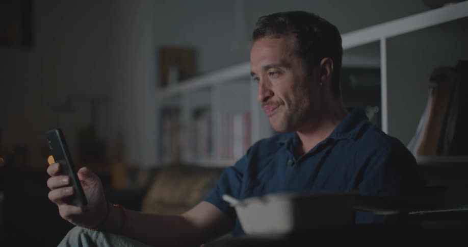 A man is using his cell phone at home
