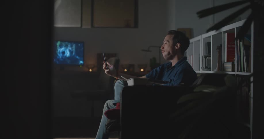 A man eats while talking on the phone during a video call