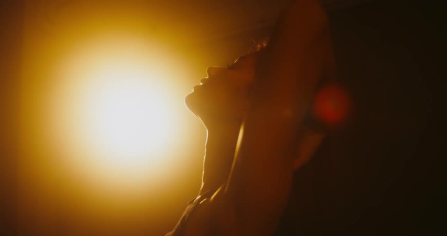 A woman is leaning up with her arms in the air