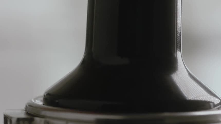 A press is being used on coffee grounds