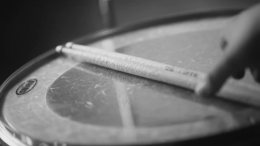 Male drummer holds drumsticks in room