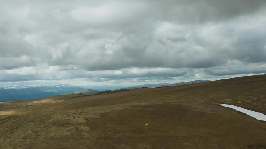 Aerial view of helicopter flying over hills on cloudy day