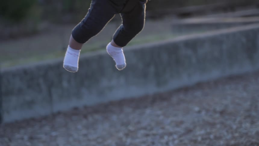 A baby swinging and her mother gives her a push