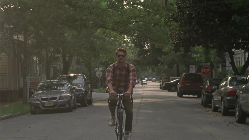 Man riding a bicycle down a city street