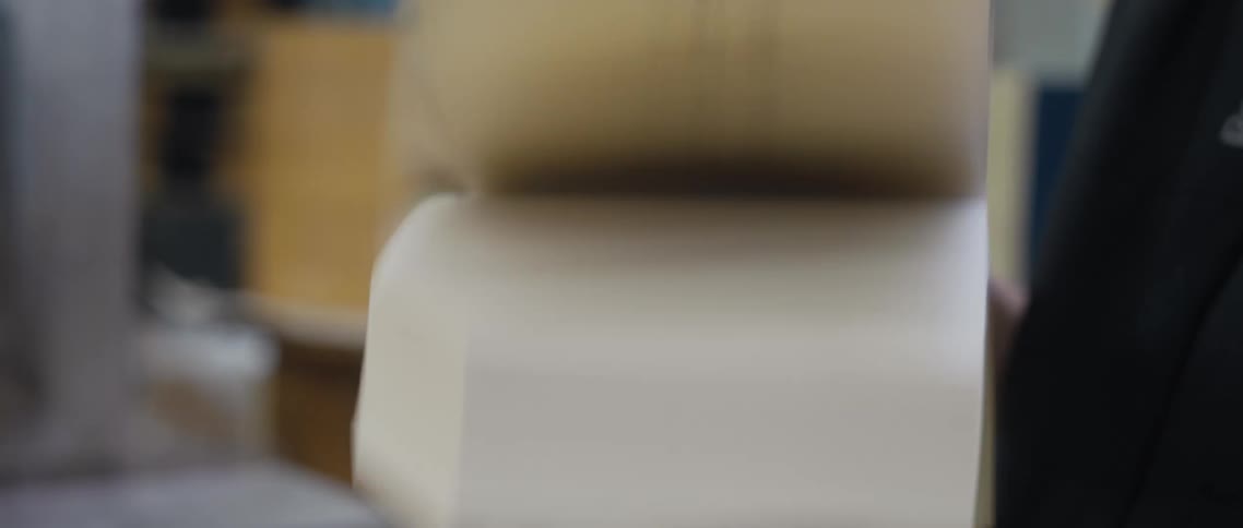 A man holds a book in his hands and flips the pages quickly