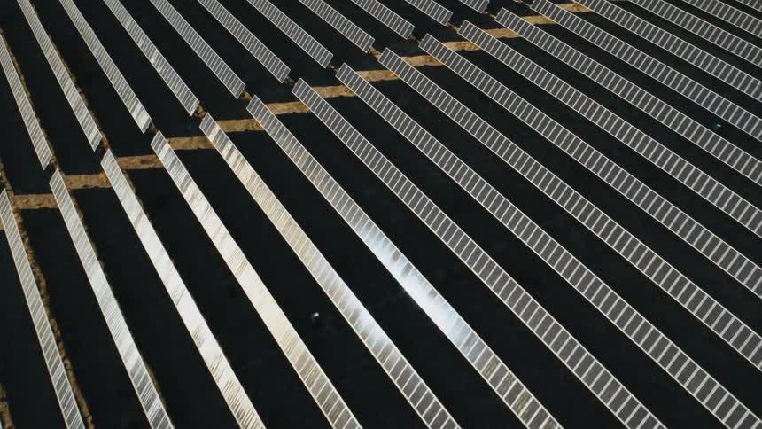 Sunlight shines on solar panels on a solar farm