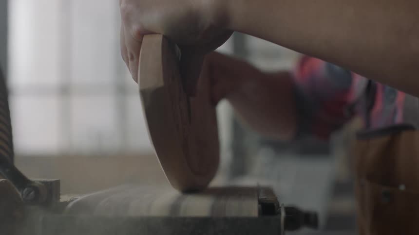 Person using a belt sander to smooth some edges