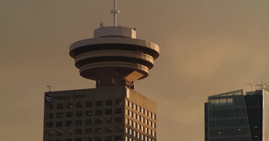Vancouver Harbour Centre tower shown under a cloudy sky at sunset